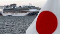 Du thuyền Diamond Princess neo ở bến tàu Daikoku, bên cạnh quốc kỳ Nhật Bản
