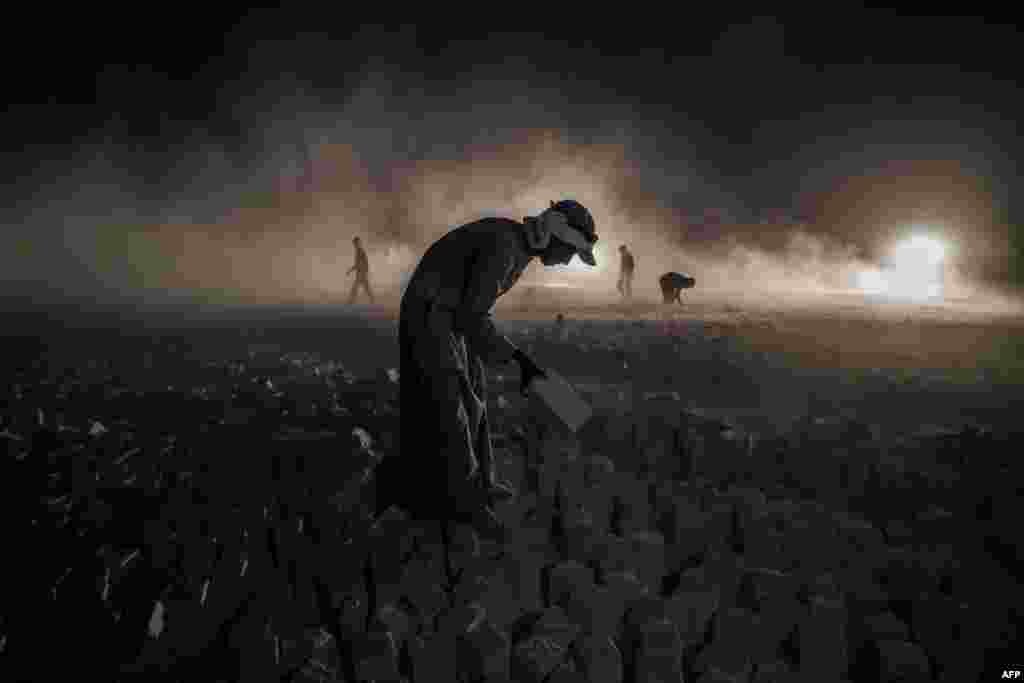 A laborer carries a stone block at the "White Mountain" limestone extraction quarry site near Egypt's southern city of Minya, some 265 kilometers south of the capital Cairo.