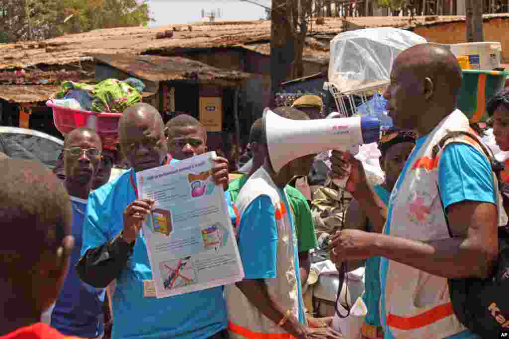 Nhân viên y tế hướng dẫn dân chúng về virus Ebola và làm thế nào để ngăn lây nhiễm tại Conakry, Guinea.