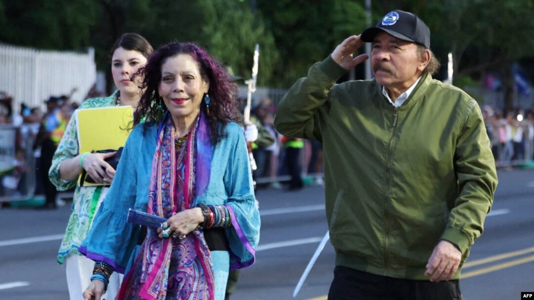 El presidente de Nicaragua, Daniel Ortega, acompañado por su esposa y vicepresidenta Rosario Murillo, saludando a su llegada a un desfile militar para conmemorar el 44º aniversario del Ejército.
