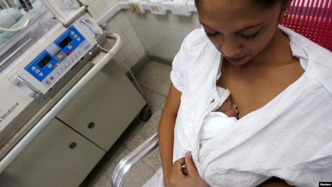 FILE - A mother performs Kangaroo care, or skin-to-skin contact, with her premature baby to give the baby the physical stimulation it needs.