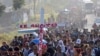 Migrantes que caminan por la carretera llevan una cruz que dice en español "Cristo Resucitado" durante la Semana Santa mientras avanzan por Tapachula en el estado mexicano de Chiapas, el lunes 25 de marzo de 2024. 