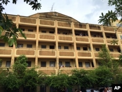 Thai police stand on the balcony outside of an apartment building in Nong Jok on the outskirts of Bangkok, Aug. 29, 2015. Thai police say they arrested a suspect in the blast at the Erawan Shrine in this apartment building.