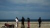ARCHIVO - Policías interceptan a dos personas que caminan por el malecón de La Habana, Cuba, el lunes 15 de noviembre de 2021. El gobierno dio por terminado el porceso de excarcelaciones de presos en la isla. Activistas mostraron su inconformidad por la medida.