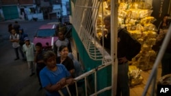 Habitantes del distrito Catia, en Caracas, esperan para recibir las bolsas de comida subsidiada por el gobierno en disputa de Nicolás Maduro, conocidas como CLAP, el 31 de enero del 2019. 