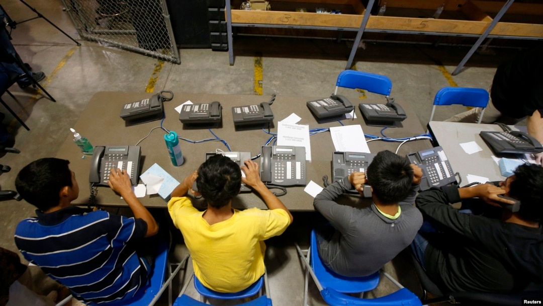 Niños aprehendidos en Arizona tratan de hacer llamadas telefónicas para comunicarse con sus familiares.