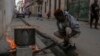 ARCHIVO - Un hombre cocina una sopa en un fuego en la acera, durante un apagón en La Habana, Cuba, el 4 de diciembre de 2024. 