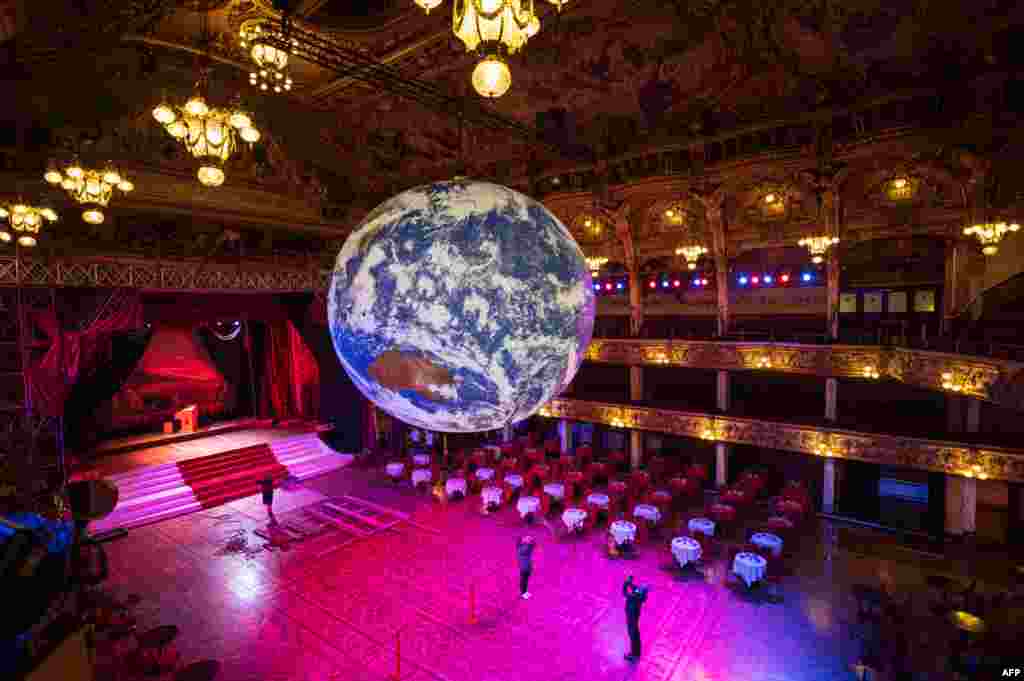 Members of the public admire an illuminated art installation entitled 'Gaia' by artist Luke Jerram in the Blackpool Tower Ballroom, as part of the Lightpool Festival of visual arts in the center of Blackpool, northern England, Oct. 14, 2019.