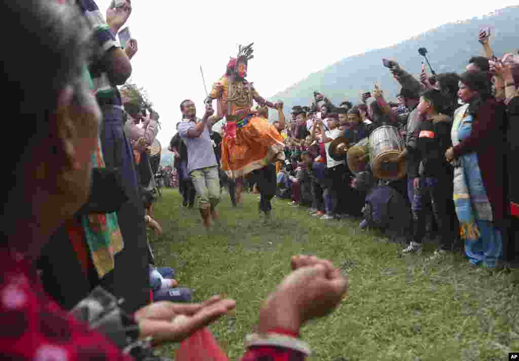Nepalese devotees carry a dancer wearing a mask of a deity during Shikali festival in Khokana, outskirts of Kathmandu, Nepal.