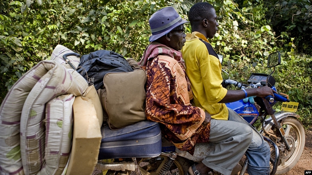 FILE - An Ivorian refugee gets a lift on motor bike taxi toward Zwedru, Liberia, March 24, 2011.