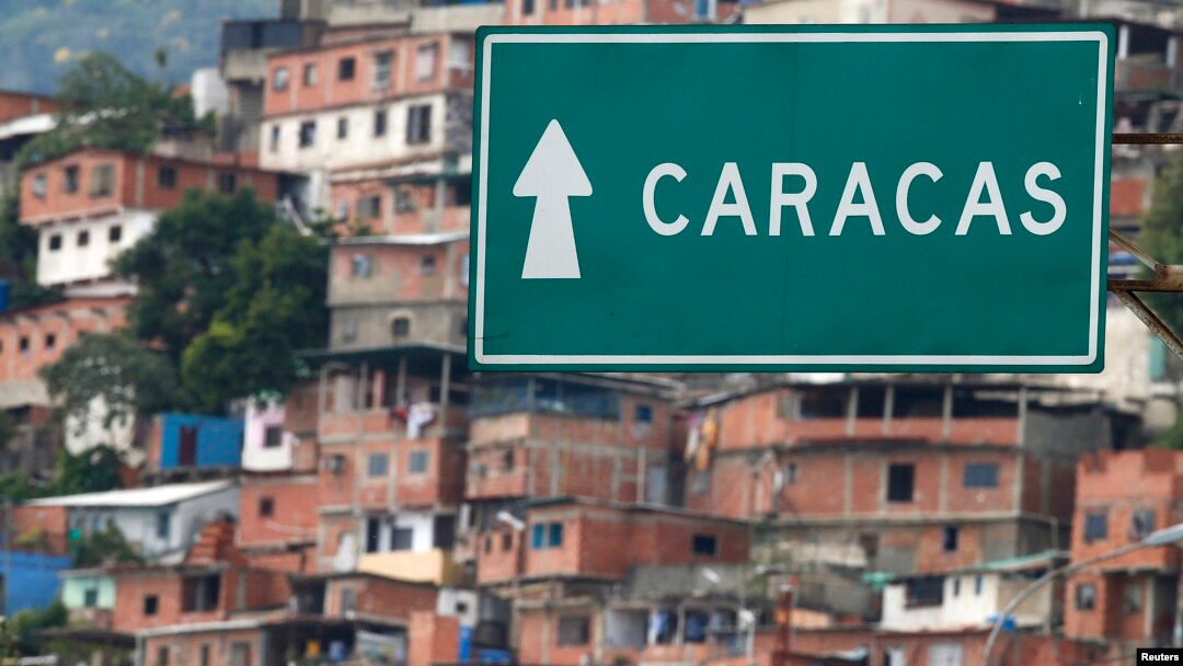 FILE - A road sign indicates the way to Caracas at Simon Bolivar international Airport in La Guaira, outside Caracas, Venezuela, July 10, 2013. 