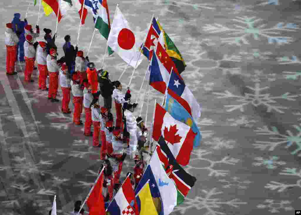 Qishki olimpiada yopilish marosimida ishtirokchi davlatlar vakillari bayroqlarini ko'tarib chiqmoqda.