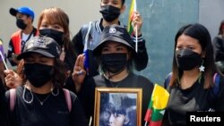 Myanmar citizens hold a portrait of former Myanmar state counselor Aung San Suu Kyi as they protest against the execution of pro-democracy activists at Myanmar's embassy in Bangkok, Thailand, on July 26, 2022. (Soe Zeya Tun/Reuters)