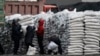 FILE - North Koreans distribute imported sacks of flour on the banks of Yalu River, near the North Korean town of Sinuiju, opposite the Chinese border city of Dandong.