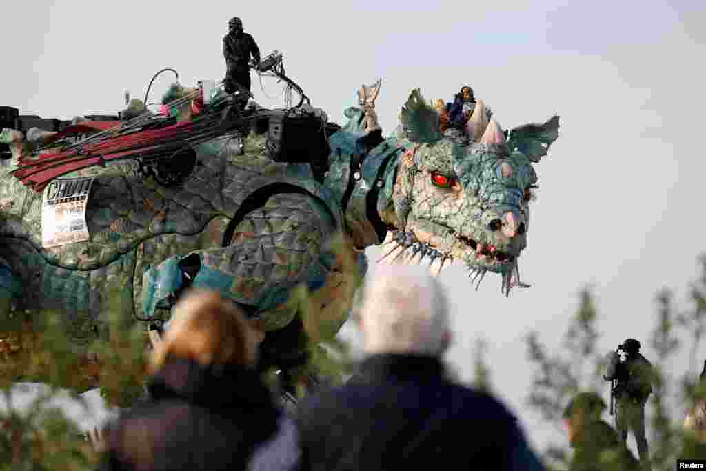People look at the "Dragon de Calais" by Francois Delaroziere and La compagnie La Machine during a rehearsal in the harbor of Calais, France, Oct. 30, 2019.