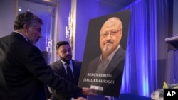 FILE - Mongi Dhaouadi (L) and Ahmed Bedier set up an image of slain Saudi journalist Jamal Khashoggi before an event to remember Khashoggi, a columnist for The Washington Post who was killed inside the Saudi Consulate in Istanbul on Oct. 2, in Washington, Nov. 2, 2018.