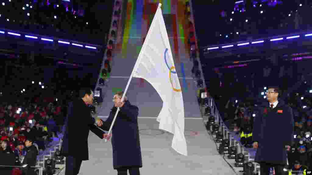Xalqaro Olimpiya qo'mitasi prezidenti Tomas Bax Olimpiada bayrog'ini Janubiy Koreyadan qabul qilib olmoqda.