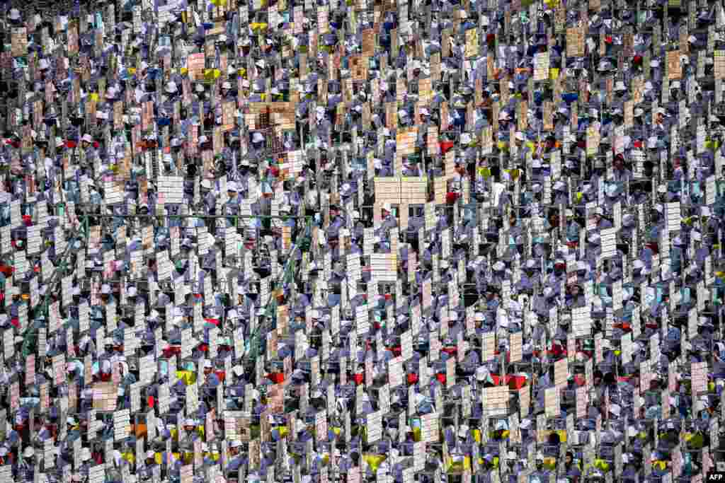 Youths hold placards for a mass display before a Holy Mass led by Pope Francis at the National Stadium in Bangkok, Thailand.