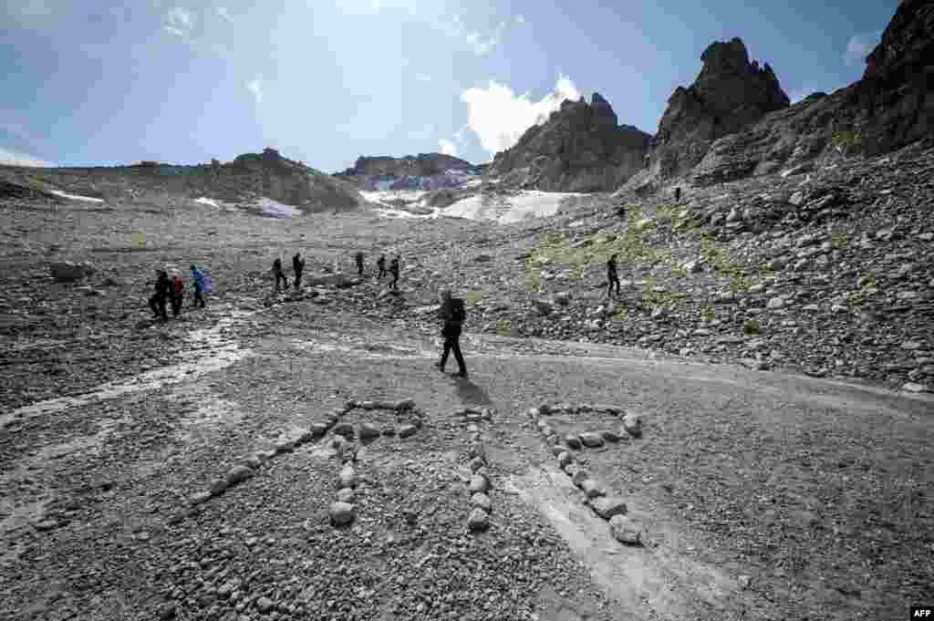 People take part in a ceremony to mark the 'death' of the Pizol glacier (Pizolgletscher) above Mels, eastern Switzerland. In a study earlier this year, researchers of ETH technical university in Zurich determined that more than 90 percent of Alpine glaciers will disappear by 2100 if greenhouse gas emissions are left unchecked.