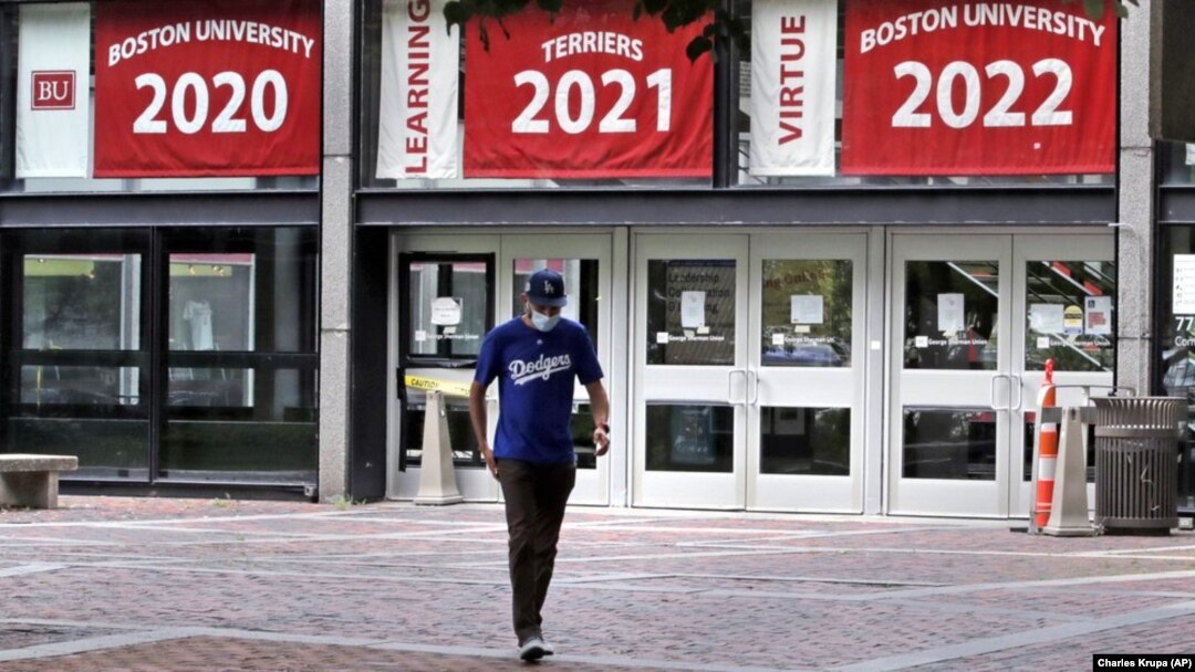 Weston Koenn, a graduate student from Los Angeles, leaves the Boston University student union building as he walks through the student-less campus, Thursday, July 23, 2020, in Boston. (AP Photo/Charles Krupa)
