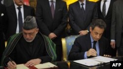 Tổng thống Pháp Nicolas Sarkozy (phải) và Tổng thống Afghanistan Hamid Karzai ký 1 hiệp ước hữu nghị và hợp tác tại Điện Elysee ở Paris, 27/1/2012