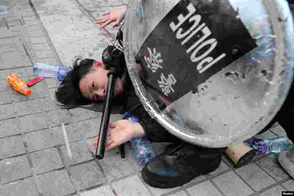 Police arrest a protester after a Chinese flag was removed from a flag pole at a rally in support of Xinjiang Uighurs' human rights in Hong Kong, China.