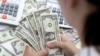A woman holds U.S. dollar banknotes in this illustration taken on May 30, 2022. (Dado Ruvic/Reuters)