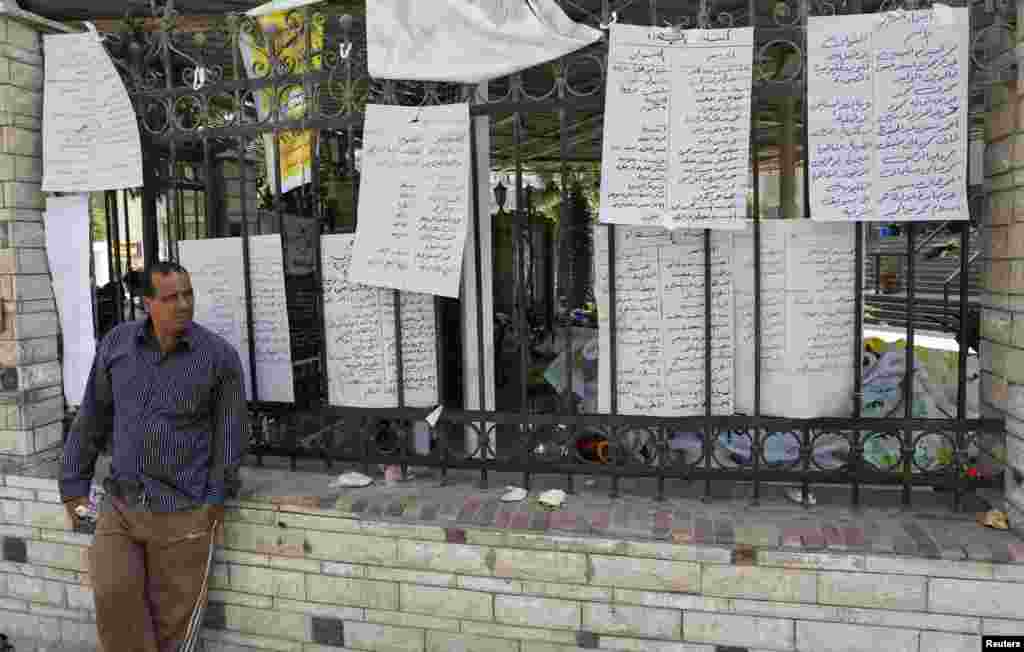 A man who lost relatives in recent violence stands near a list of names of dead members of the Muslim Brotherhood and supporters of deposed Egyptian President Mohamed Morsi at El Eyman mosque in Cairo, August 16, 2013.