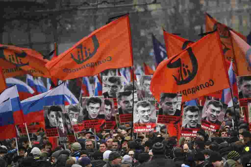 Người tuần hành tưởng nhớ lãnh đạo đối lập Boris Nemtsov mang biểu ngữ xuống đường với hàng chữ "Những viên đạn cho tất cả chúng ta, những anh hùng không bao giờ chết!" tại Moscow, Nga, ngày 1/3/2015.
