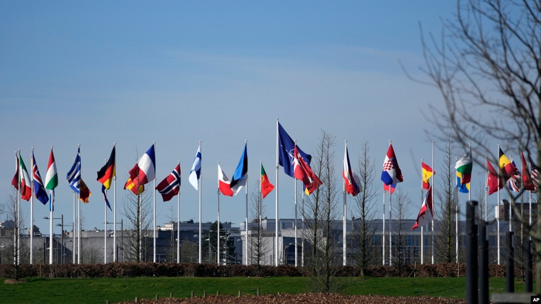 ARCHIVO - Banderas de los países miembros de la OTAN ondean al viento afuera en la sede de la OTAN en Bruselas, el 14 de marzo de 2024.