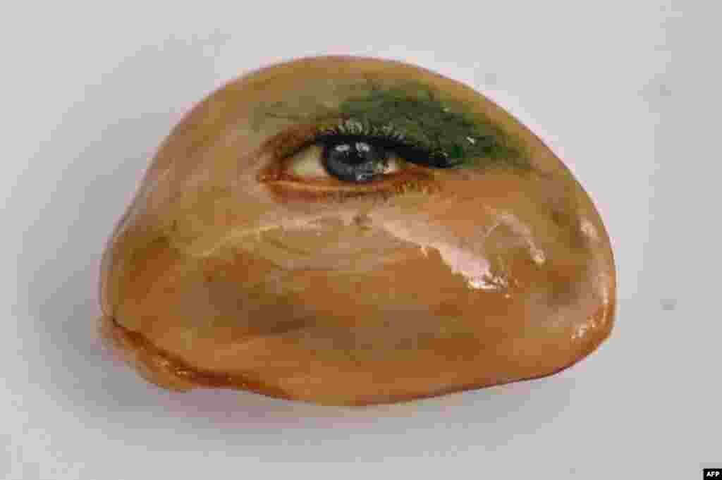 An eye painted on a fruit seed by Turkey's micro artist Hasan Kale in Istanbul, Turkey. The artist, also known as Turkish Microangelo in reference to Italian Renaissance sculptor and painter Michelangelo, has been hitting his brush onto tiny everyday objects for more than two decades.