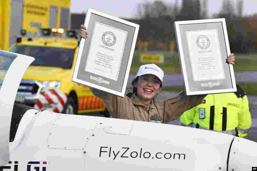 Belgium-British teenage pilot Zara Rutherford holds up her certificates after landing her Shark ultralight plane at the Kortrijk airport in Kortrijk, Belgium, Jan. 20, 2022. The 19-year-old has set a world record as the youngest woman to fly solo around the world, touching her small airplane down in western Belgium, 155 days after she departed. 