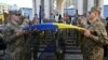 Los militares ucranianos sostienen la bandera ucraniana sobre el ataúd de Sergii Konoval durante la ceremonia de despedida de los militares ucranianos Sergii Konoval. [Foto: Archivo/AFP]