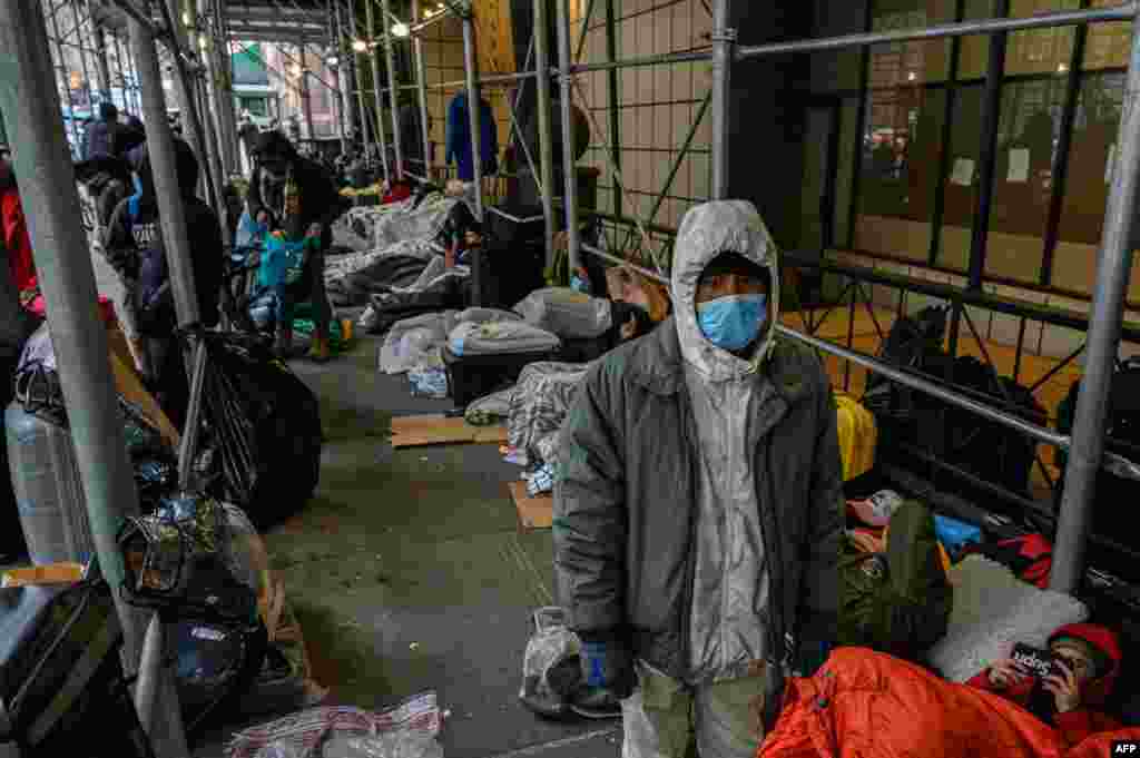 Migrants camp outside a hotel as they resist efforts by the city to relocate them to a Brooklyn facility for asylum seekers, in the Hells Kitchen neighborhood of New York, Jan. 31, 2023.