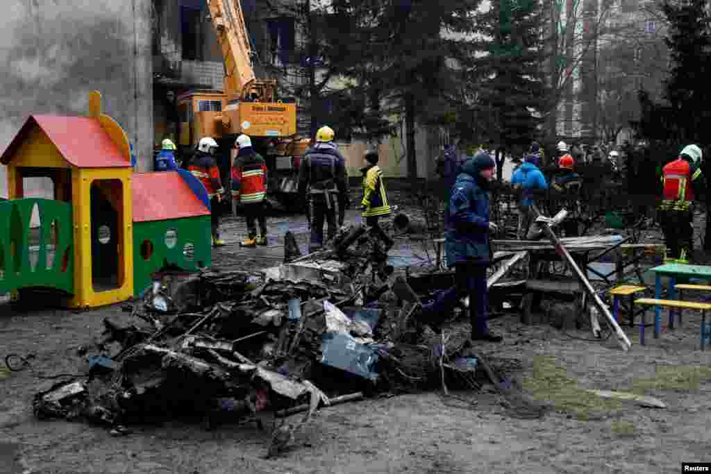 Emergency personnel work at the site of a helicopter crash in the town of Brovary, outside Kyiv, Ukraine. A helicopter crashed into a nursery and set it ablaze in a suburb of the capital. killing at least 14 people, including Interior Minister Denys Monastyrskyi.