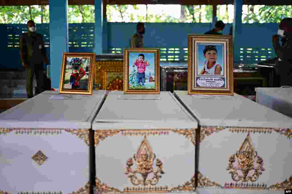 Portraits of young victims of a mass shooting in a nursery are displayed atop their coffins as funeral preparations get underway at Wat Si Uthai temple in Thailand's northeastern Nong Bua Lam Phu province.