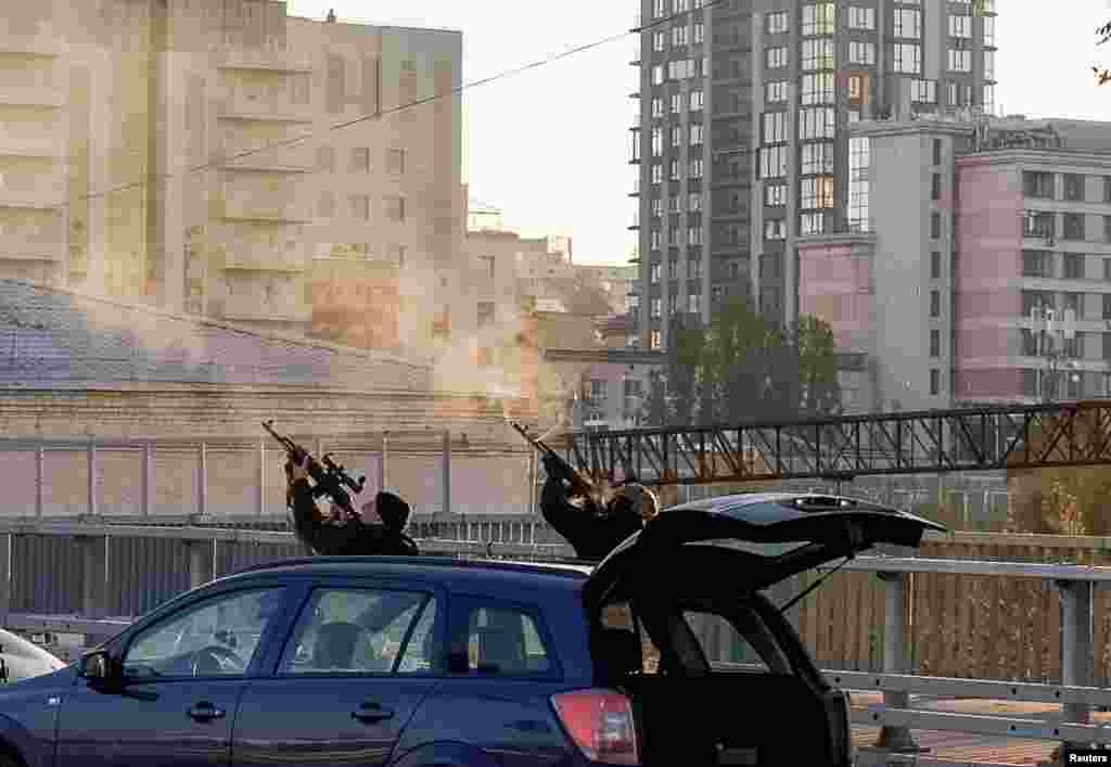 Police officers shoot at a drone during a Russian drone strike, which local authorities consider to be Iranian-made Shahed-136 unmanned aerial vehicles (UAVs), in Kyiv, Ukraine.