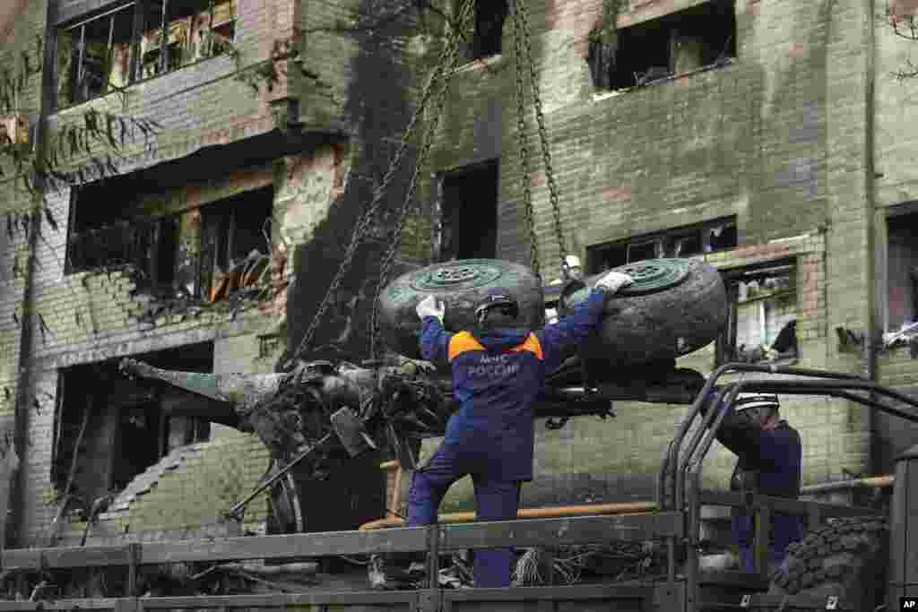 Emergency workers load debris of a warplane on a truck at the scene of a plane crash in a residential area in Yeysk, Russia. The death toll from the crash of a Russian warplane into a nine-story apartment building has risen to 15. 