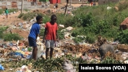 Crianças despejam o lixo em lixeira a céu aberto em Malanje