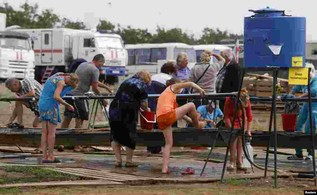 People clean themselves at a refugee camp set up for Ukrainians in Russia's Rostov region near the Russia-Ukraine border, Aug. 18, 2014.