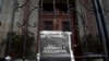 ARCHIVO - Una copia de la portada de elPeriódico, que reza "Periodistas asesinados", cuelga en una puerta principal de la Casa Presidencial durante una protesta en marzo de 2015.