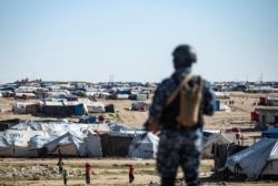 FILE - Special forces of the Syrian Democratic Forces keep watch in the vicinity of al-Hol camp, in Syria's northeast, March 30, 2021.