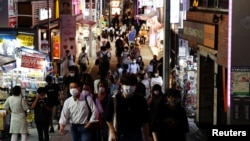 People wearing protective masks, amid the coronavirus disease (COVID-19) outbreak, make their way at a shopping district in Tokyo, Japan, July 28, 2021.
