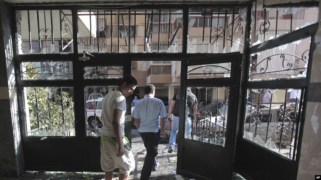 Lebanese citizens leave a destroyed building that was damaged during clashes erupted between pro- and anti-Syrian Sunni groups, in Beirut, Lebanon, May 21, 2012.