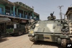 FILE - Pakistani army soldiers patrol in Miran Shah bazaar after driving out militants from the tribal region of North Waziristan along the Afghanistan border, July 9, 2014.