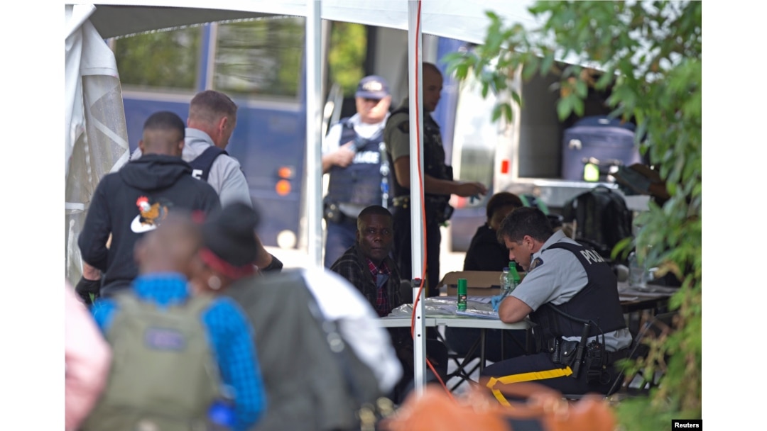 FILE - Refugees are processed by the Royal Canadian Mounted Police (RCMP) after crossing illegally into Canada at the U.S.-Canada border on Roxham Road from Champlain, New York, August 3, 2017.