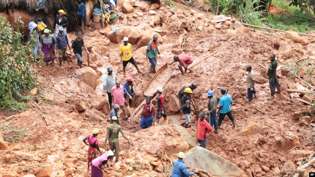 Family members dig for their son, who got buried in the mud when Cyclone Idai struck in Chimanimani about 600 kilometers southeast of Harare, Zimbabwe, March 19, 2019. 
