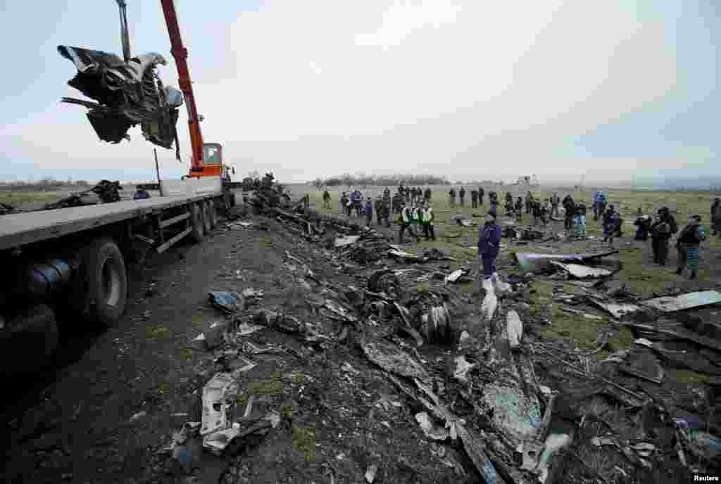 A crane carries wreckage of the Malaysia Airlines Flight MH17 at the site of the plane crash near the settlement of Grabovo in the Donetsk region, Nov. 16, 2014.
