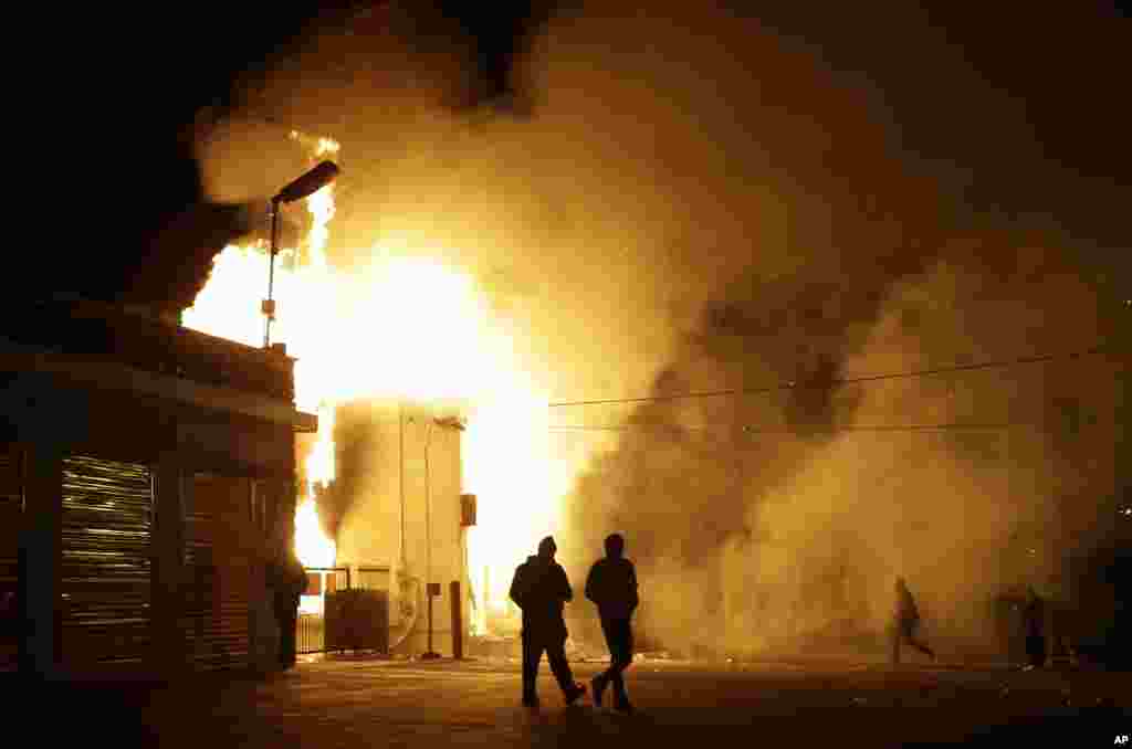 Pessoas afastam-se de um armazém em chamas depois de anunciada a decisão do Grande Júri de que o polícia que atirou fatalmente em Michael Brown não será acusado. Ferguson, Missouri, Nov. 24, 2014.
