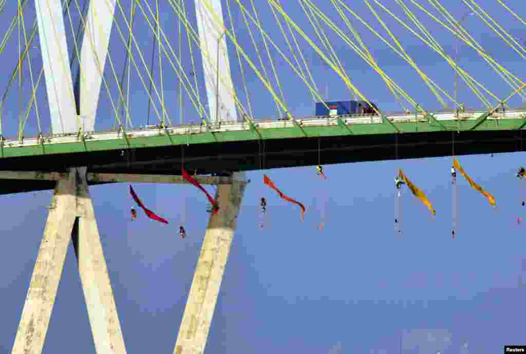 Greenpeace USA climbers form a blockade on the Fred Hartman Bridge, shutting down the Houston Ship Channel, the largest fossil fuel thoroughfare in the United States, ahead of the third Democratic primary debate in nearby Houston, near Baytown, Texas. (©Anonymous/Greenpeace USA)